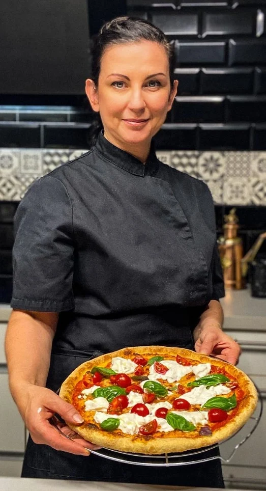 Emma présente une pizza dans sa cuisine