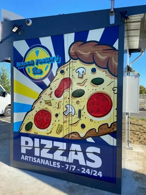 Habillage bleu et jaune de la Napoli Factory Box avec une grande part de pizza