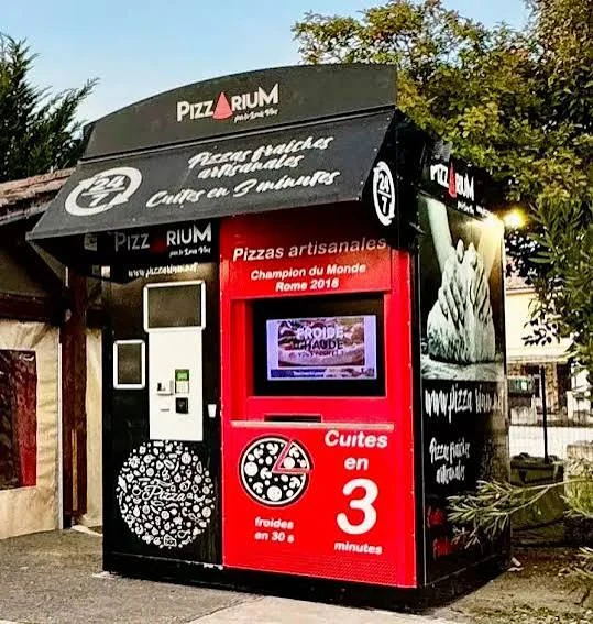 Distributeur à l’habillage Pizzarium noir et rouge près de la pizzeria